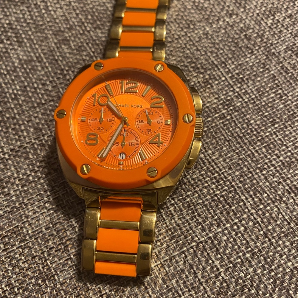 Michael Kors orange and gold watch.